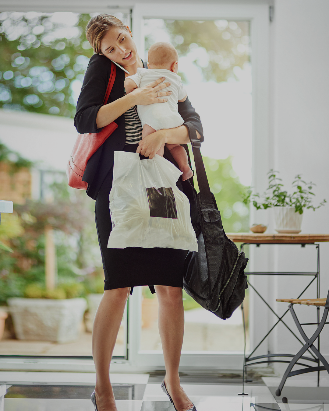 Working mom carrying baby and multiple bags representing mental load and executive function overwhelm