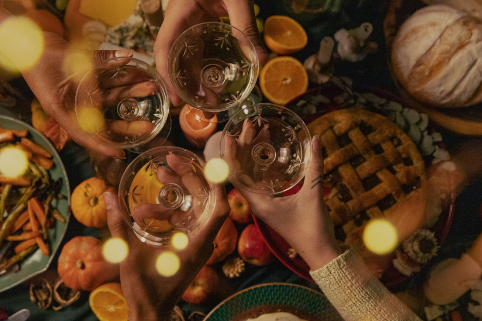 Family clinking glasses at a crowded holiday dinner table — bright lights, strong colors, and lots of sensory input.