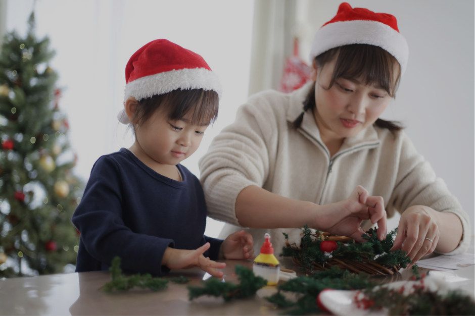 A mother and child in Santa hats doing a simple Christmas craft at a table. Image promotes a holiday survival guide for neurodivergent moms who need low-effort, sensory-friendly ideas.
